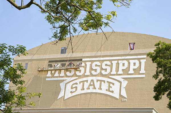 Workers paint MSU's logo on the back of the video board