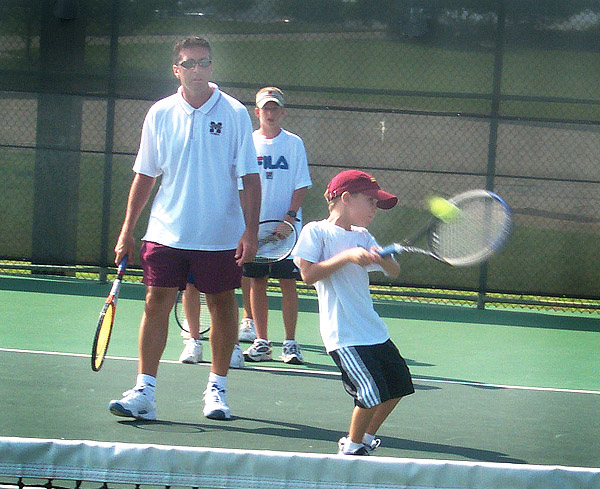 Daniel Chambers hits a backhand at tennis camp