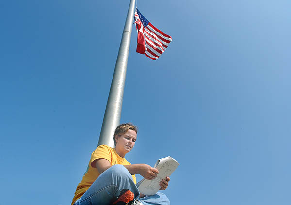 Student studies under half mast flag