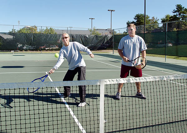 Students volley tennis ball in class