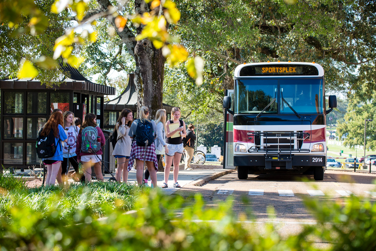 A group of female students wait at Montgomery Hall&amp;amp;#039;s bus stop as the shuttle arrives.