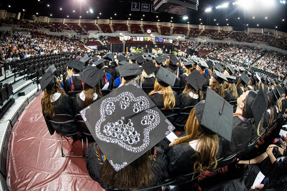 A rhinestone bulldog pawprint decorates the back of a graduate&amp;amp;#039;s mortar board in a sea of fellow graduates in Humprhey Coliseum.