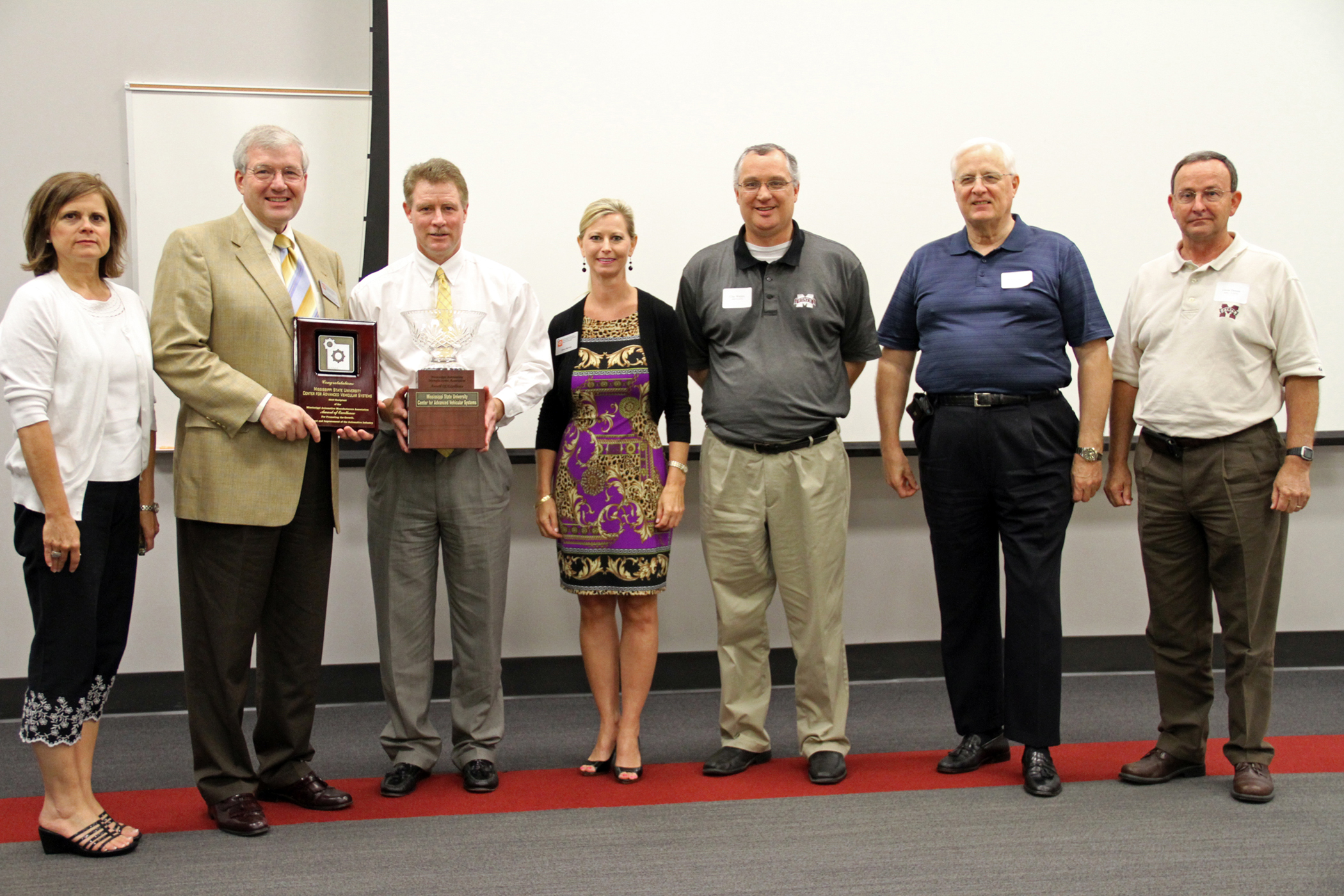 Mississippi Automotive Manufacturers Association board member Glenn Boyce (third from left), president of Holmes Community College, presented the 2010 Award of Excellence to Roger King (second from left), director of the Center for Advanced Vehicular Systems at Mississippi State University. Also pictured (from left) are Jill Sellers, MSU CAVS Extension, Canton; King; Boyce; Gina Harvey, 2010 MAMA president; and Clay Walden, Robert Sheely and Glen Dennis, all of the MSU CAVS Center in Canton. Mississippi Automotive Manufacturers Association board member Glenn Boyce (third from left), president of Holmes Community College, presented the 2010 Award of Excellence to Roger King (second from left), director of the Center for Advanced Vehicular Systems at Mississippi State University. Also pictured (from left) are Jill Sellers, MSU CAVS Extension, Canton; King; Boyce; Gina Harvey, 2010 MAMA president; and Clay Walden, Robert Sheely and Glen Dennis, all of the MSU CAVS Center in Canton.