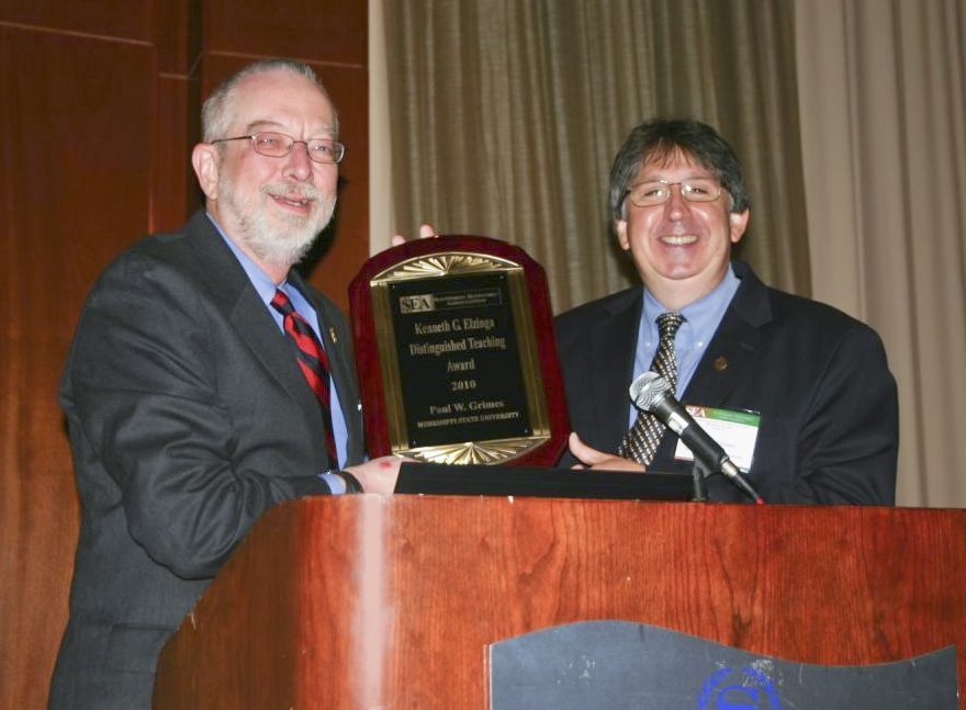 Paul Grimes, right, is presented the Southern Economic Association's Kenneth G. Elzinga Distinguished Teaching Award by the organization's president, William Shugart, a professor of economics at The University of Mississippi. Paul Grimes, right, is presented the Southern Economic Association's Kenneth G. Elzinga Distinguished Teaching Award by the organization's president, William Shugart, a professor of economics at The University of Mississippi.