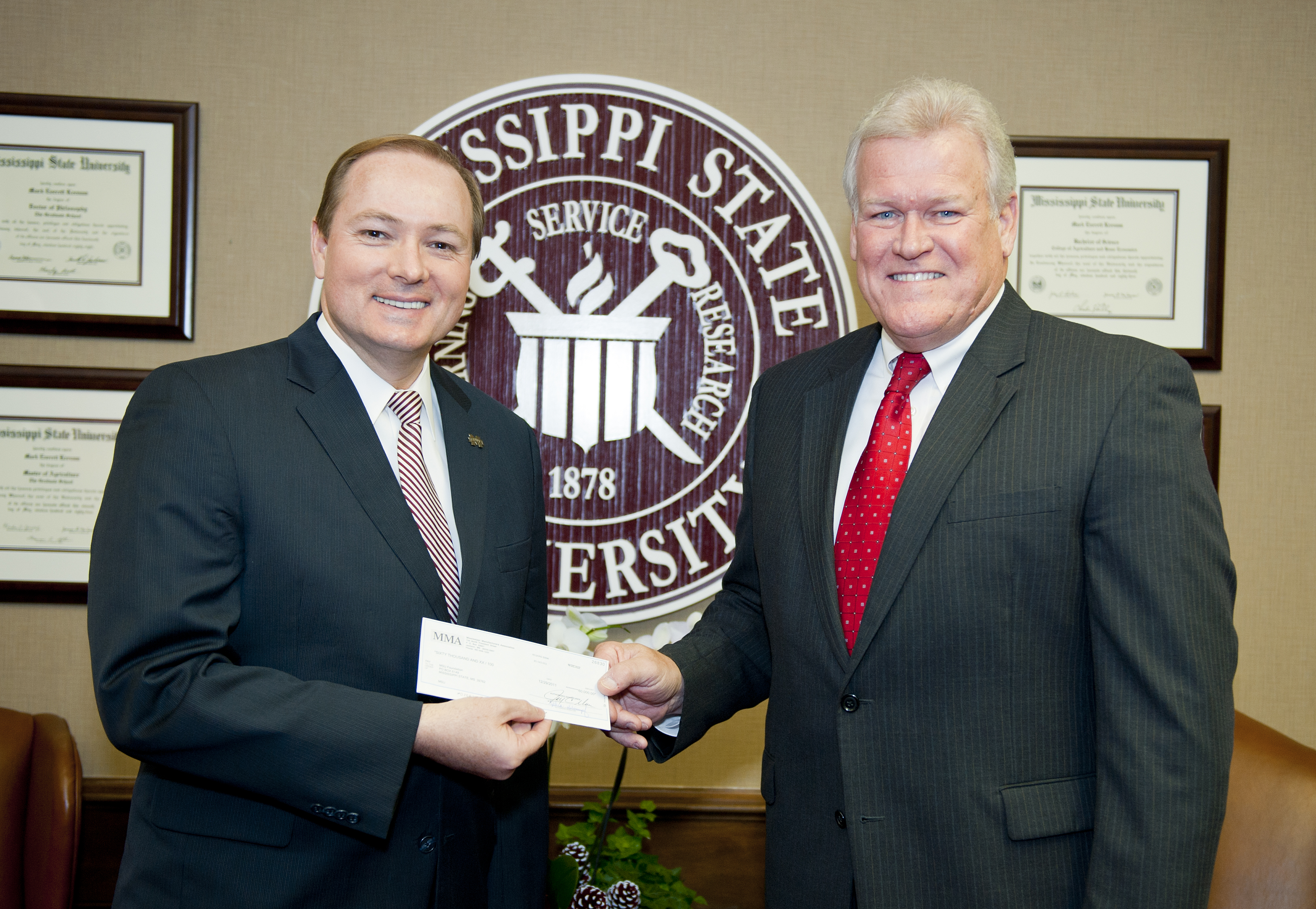 MSU President Mark Keenum, left, accepts the Mississippi Manufacturers Association gift from Jay Moon. MSU President Mark Keenum, left, accepts the Mississippi Manufacturers Association gift from Jay Moon.