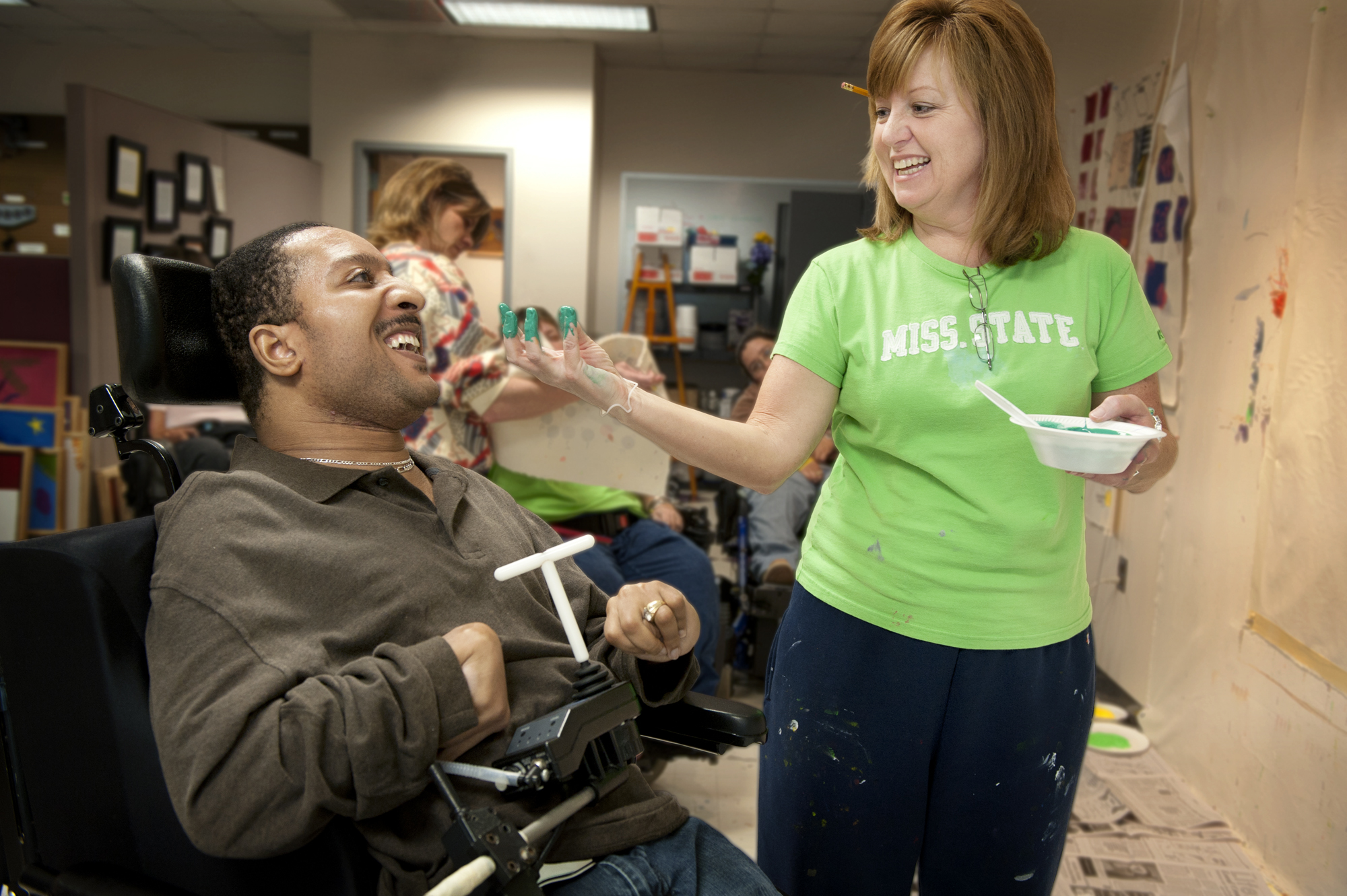 Judy Duncan of MSU's T.K. Martin Center, works with Thalamus Brown, who has cerebral palsy, to help him paint in the EXPRESS Yourself program. Judy Duncan of MSU's T.K. Martin Center, works with Thalamus Brown, who has cerebral palsy, to help him paint in the EXPRESS Yourself program.