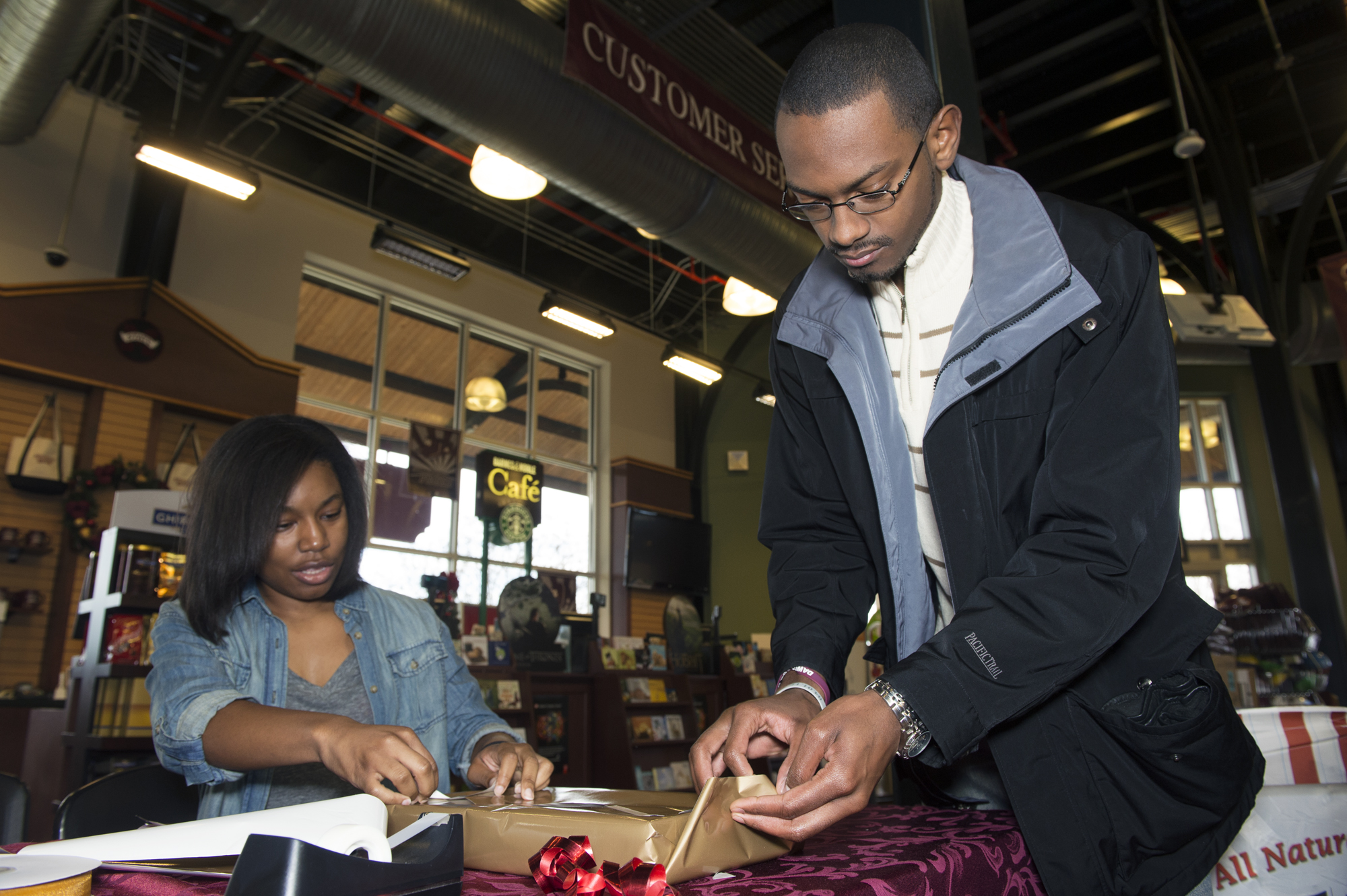 Fredricka Brown, Maroon Volunteer Center service leader, and Christopher Ferrell, MVC graduate assistant, wrap a gift as part of the Wrap a Gift Project, launched by MSU's Habitat for Humanity student organization. Fredricka Brown, Maroon Volunteer Center service leader, and Christopher Ferrell, MVC graduate assistant, wrap a gift as part of the Wrap a Gift Project, launched by MSU's Habitat for Humanity student organization.