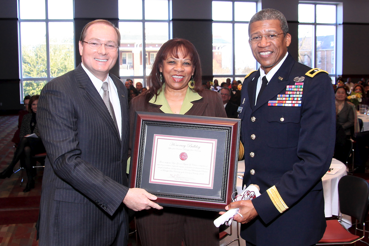 Mississippi State University President Mark E. Keenum. left, confers "Honorary Bulldog" status on Mississippi Adjutant Gen. Augustus L. Collins, right, speaker for MSU's annual community Martin Luther King Jr. Day Unity breakfast held Monday in the Colvard Student Union. Shown at center is the general's wife, Mrs. Debra Collins. Hundreds attended the event, which featured a celebration of King's life and work. Collins is the first African-American to lead the Mississippi Army and Air National Guard. Mississippi State University President Mark E. Keenum. left, confers "Honorary Bulldog" status on Mississippi Adjutant Gen. Augustus L. Collins, right, speaker for MSU's annual community Martin Luther King Jr. Day Unity breakfast held Monday in the Colvard Student Union. Shown at center is the general's wife, Mrs. Debra Collins. Hundreds attended the event, which featured a celebration of King's life and work. Collins is the first African-American to lead the Mississippi Army and Air National Guard.