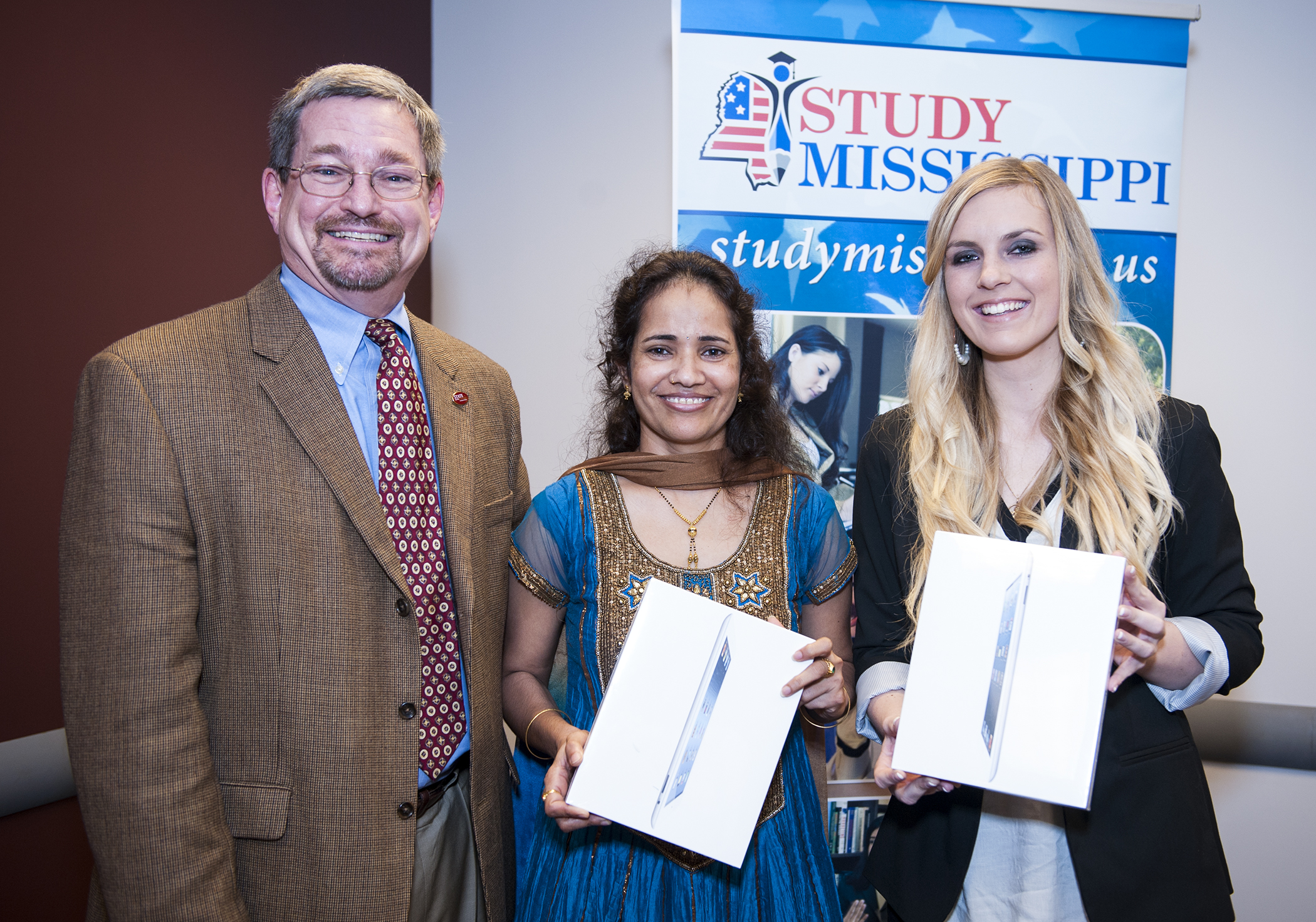 MSU International Institute Director Benjy Mikel, from left, congratulates Aparna Krishnavajhala of India and Katja Walter of Germany for their honors as StudyMississippi Students of the Year. Both honorees received iPads at a reception in their honor. MSU International Institute Director Benjy Mikel, from left, congratulates Aparna Krishnavajhala of India and Katja Walter of Germany for their honors as StudyMississippi Students of the Year. Both honorees received iPads at a reception in their honor.