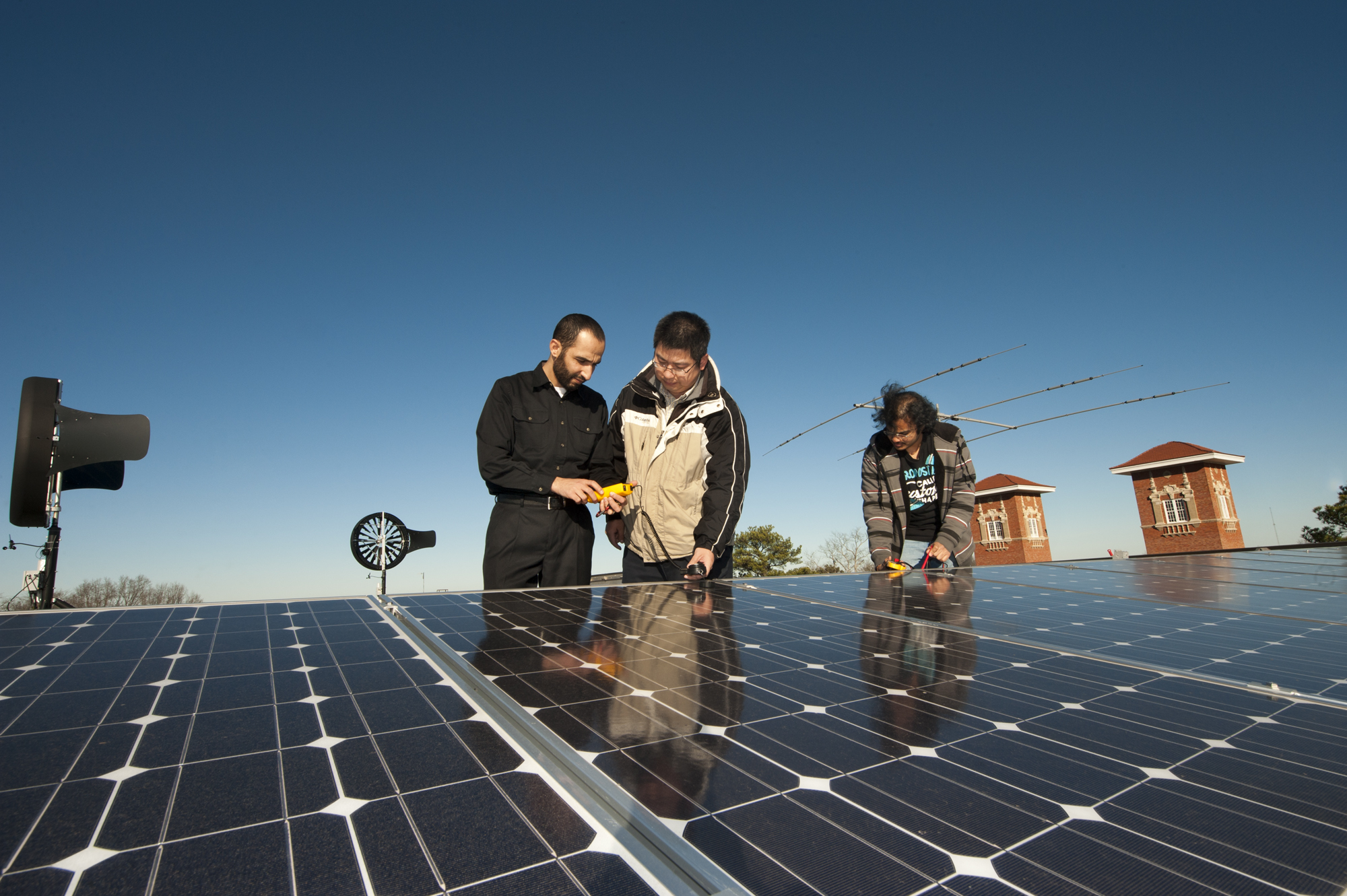 Mississippi State University's Simrall Electrical & Computer Engineering Building features an energy farm with solar panels and wind turbines on the roof. From left, doctoral candidate Saher Albatran, assistant professor Yong Fu and master's candidate Chiranjeevi Madvesh determine how much energy is being generated. Mississippi State University's Simrall Electrical & Computer Engineering Building features an energy farm with solar panels and wind turbines on the roof. From left, doctoral candidate Saher Albatran, assistant professor Yong Fu and master's candidate Chiranjeevi Madvesh determine how much energy is being generated.
