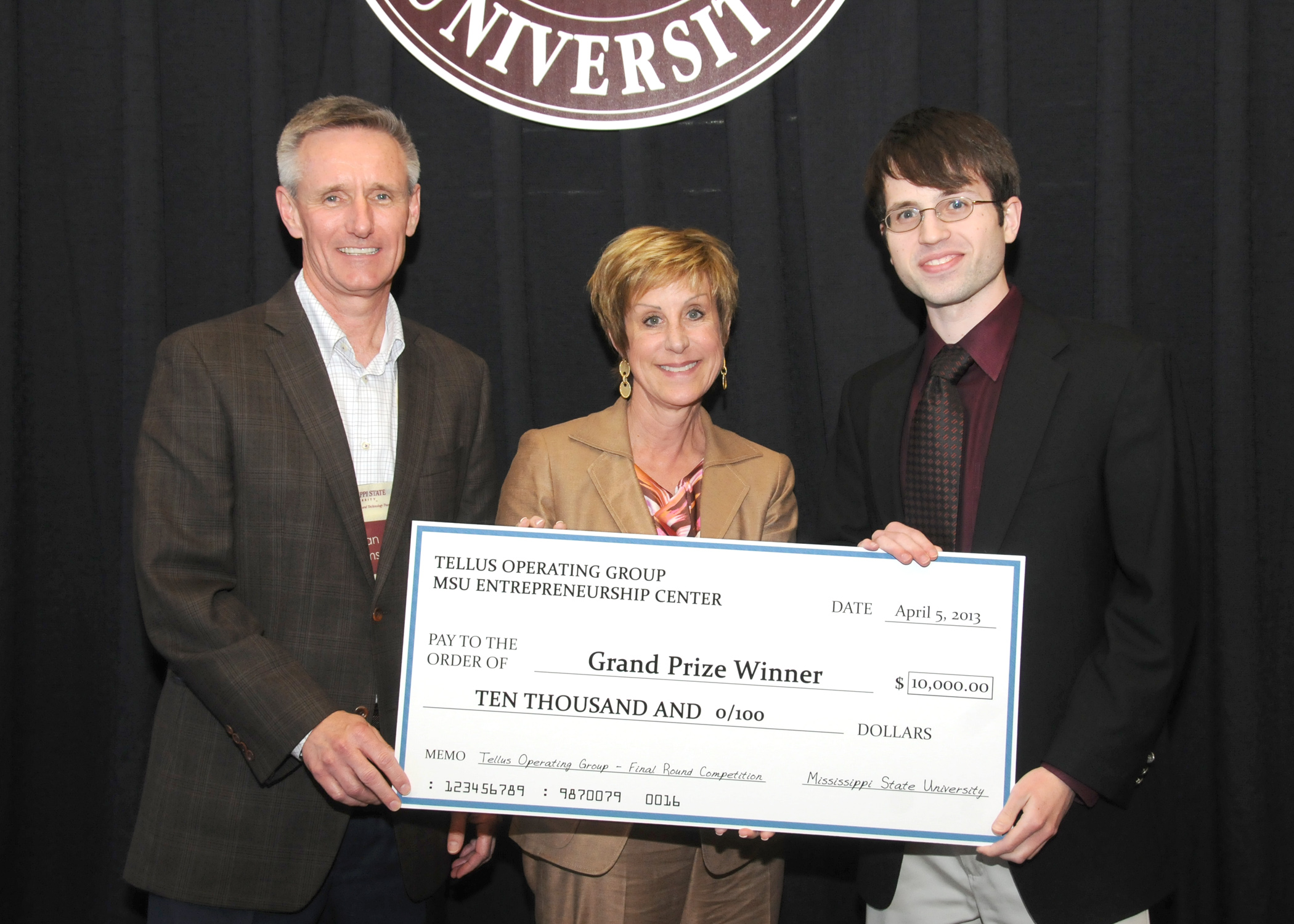 Brian Sims, from left, representing Tellus Operating Group, LLC, and MSU Dean of Business Sharon Oswald, present the grand prize award check for the final business plan competition to Read Sprabery, representing Nimbus Mobile. Brian Sims, from left, representing Tellus Operating Group, LLC, and MSU Dean of Business Sharon Oswald, present the grand prize award check for the final business plan competition to Read Sprabery, representing Nimbus Mobile.