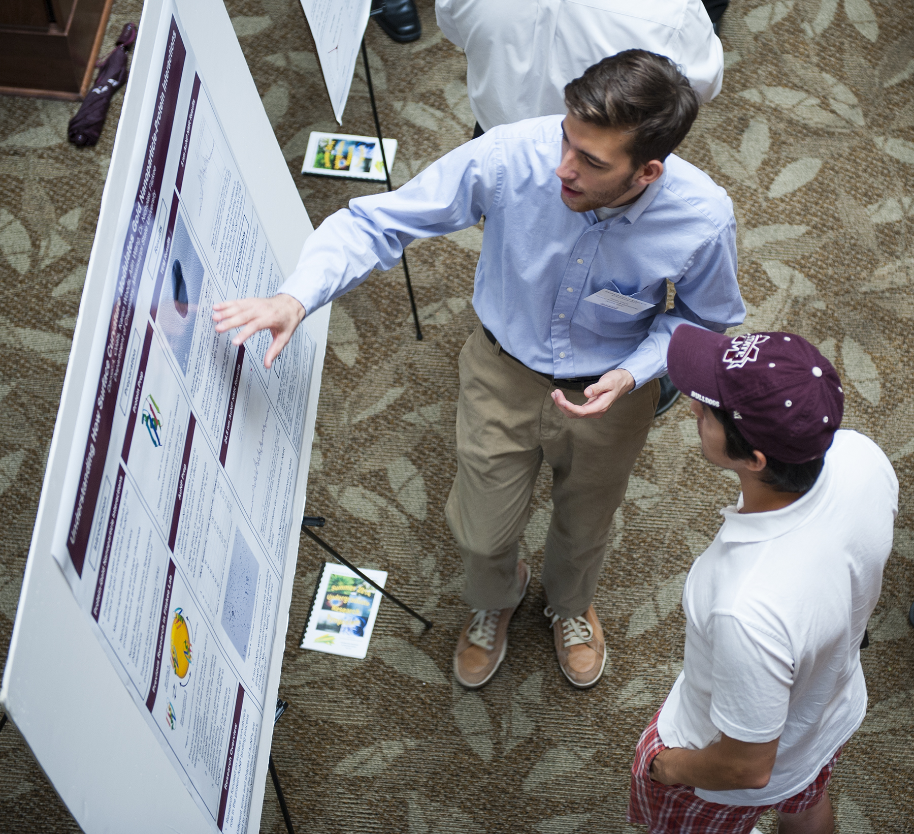 At Mississippi State's summer Undergraduate Research Symposium, sophomore chemistry major D. Alex Coats, son of William and Deborah Coats of College Station, Texas, explains his research to mechanical engineering doctoral student Pratik Parajuli. At Mississippi State's summer Undergraduate Research Symposium, sophomore chemistry major D. Alex Coats, son of William and Deborah Coats of College Station, Texas, explains his research to mechanical engineering doctoral student Pratik Parajuli.