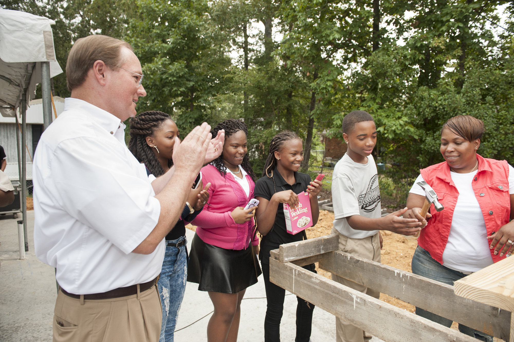 MSU President Mark E. Keenum claps as Angela Lindsey, right, passes a hammer to her son Dellveon Lindsey during the groundbreaking ceremony for the new Maroon Edition Habitat for Humanity home Monday. Looking on with Keenum are Lindsey's daughters, Lakedria Tate, Cedrianna Tate and Mya Elliott. MSU President Mark E. Keenum claps as Angela Lindsey, right, passes a hammer to her son Dellveon Lindsey during the groundbreaking ceremony for the new Maroon Edition Habitat for Humanity home Monday. Looking on with Keenum are Lindsey's daughters, Lakedria Tate, Cedrianna Tate and Mya Elliott.