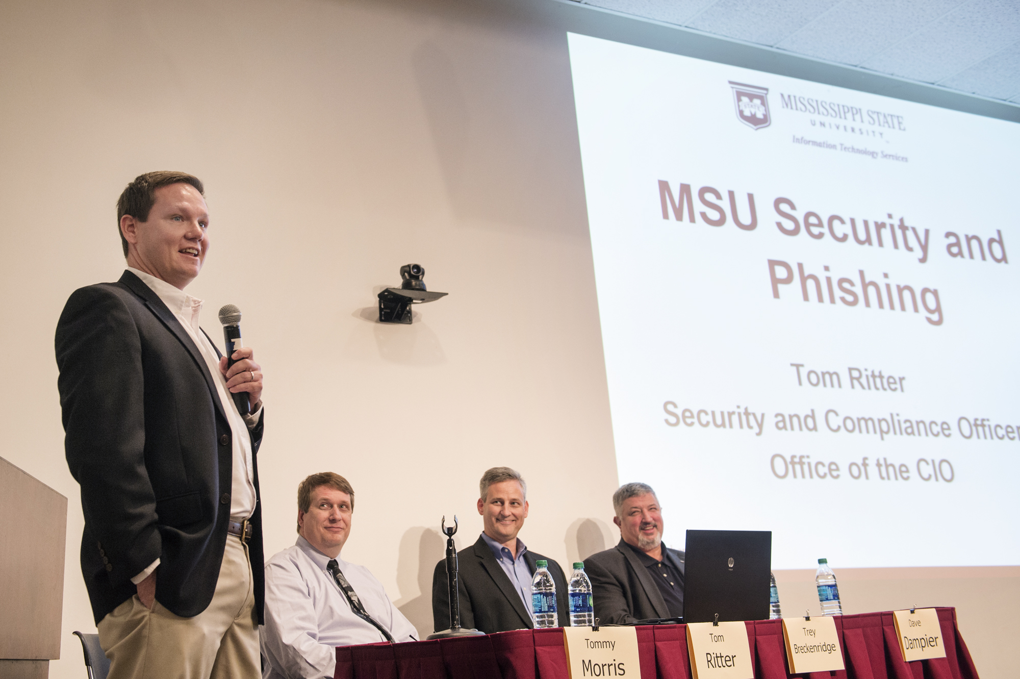 Mississippi State University hosted an expert panel on Thursday as part of Cybersecurity Awareness Week. Tommy Morris, standing, associate professor and associate director of MSU's Distributed Analytics and Security Institute, takes a question from the audience. Seated, from left, are panelists Tom Ritter, campus security and compliance officer; Trey Breckenridge, director of MSU's Portera High Performance Computing Center; and Dave Dampier, professor and director of DASI.