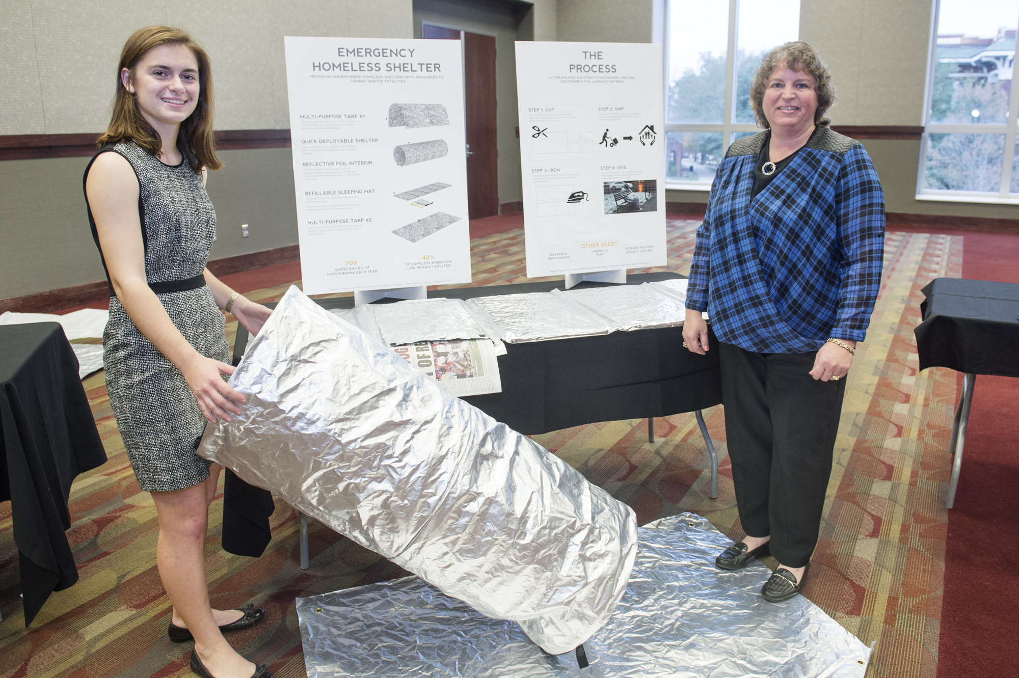 Architecture student Emily Turner, left, presents her project, a water-proof shelter for the homeless designed from a foil laminate material. Amy Vickery, who works with environmental and sustainability management for Southwire Company, LLC, which sponsored the Sustainability Challenge, said Turner's design shows great promise.