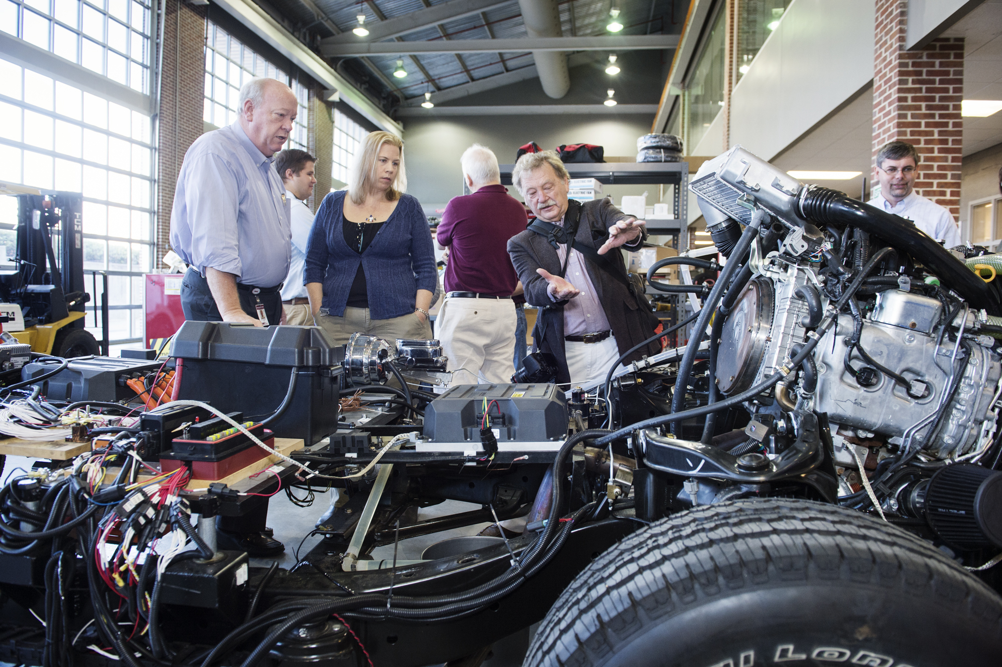 Zach Rowland, left, of Mississippi State's Center for Advanced Vehicular Systems, looks on with Katy Lusky and Dale Aspy of the Environmental Protection Agency as they discuss the "Car of the Future" project which demonstrates leading technology in vehicle performance and energy efficiency.