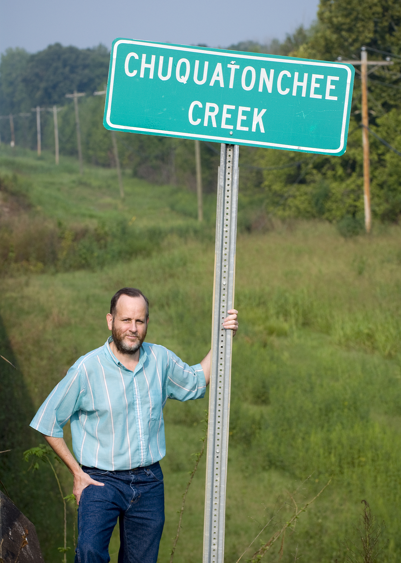 MSU graduate student Keith Baca stands before the Chuquatonchee Creek bridge sign in rural Clay County. Pronounced "suh-kuh-TOHN-chee," the word of Chickasaw-Choctaw origin translates as "hog corn." MSU graduate student Keith Baca stands before the Chuquatonchee Creek bridge sign in rural Clay County. Pronounced "suh-kuh-TOHN-chee," the word of Chickasaw-Choctaw origin translates as "hog corn."