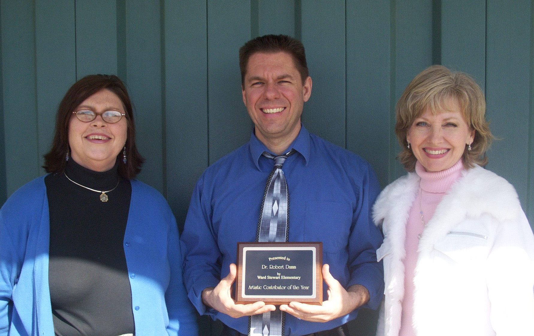 Robert J. Damm receives the Ward-Stewart Elementary School honor from assistant principal Susan Watts (l) and music teacher Cindy Melby. Robert J. Damm receives the Ward-Stewart Elementary School honor from assistant principal Susan Watts (l) and music teacher Cindy Melby.