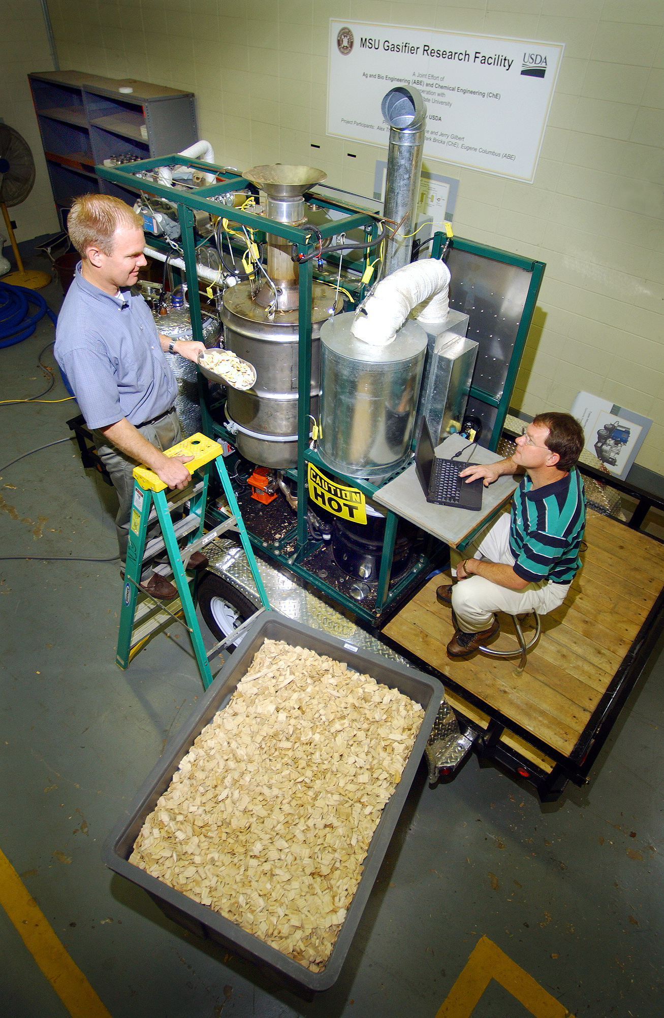 <br /><br />
Mississippi State researchers Alex Thomasson (l) and Mark Bricka feed wood<br /><br />
chips into the university's recently purchased Biomax gasifier, one of only six<br /><br />
such machines in the world. <br /><br />
Mississippi State researchers Alex Thomasson (l) and Mark Bricka feed wood<br /><br />
chips into the university's recently purchased Biomax gasifier, one of only six<br /><br />
such machines in the world.