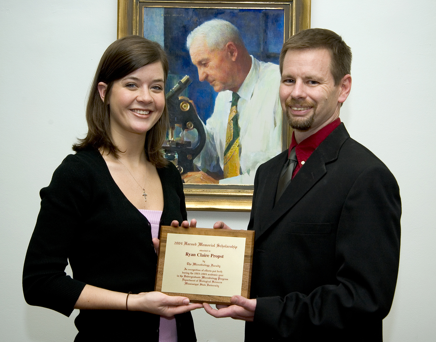 MSU Harned Scholar Ryan Propst and biological sciences faculty member Jeff Echols stand before a portrait of the award's namesake. MSU Harned Scholar Ryan Propst and biological sciences faculty member Jeff Echols stand before a portrait of the award's namesake.