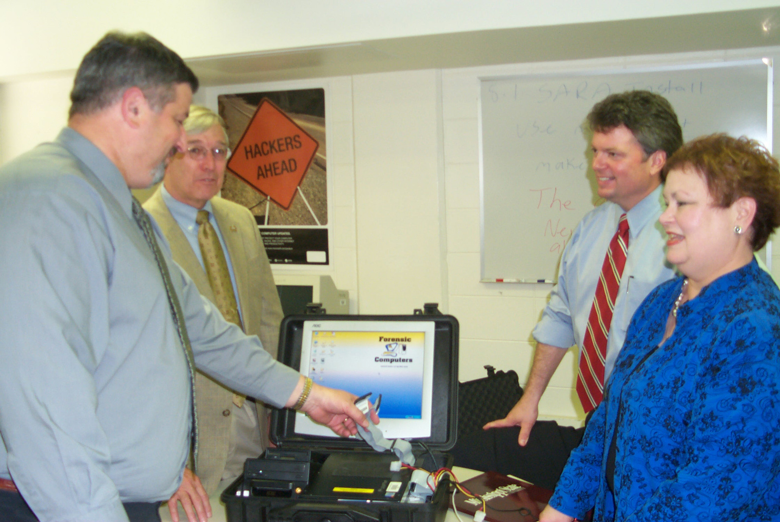 Examining a "computer forensics work center in a suitcase" at Mississippi State's Center for Computer Security recently were, l-r, MSU computer science and engineering professors Dave Dampier and Ray Vaughn, state Attorney General Jim Hood and Jean Smith Vaughan, special assistant attorney general for cyber crime. The attorney general's office and the FBI will collaborate with MSU and Jackson State University to establish a law enforcement training center in Jackson devoted to fighting such Internet-related crimes as pornography and identity theft. Examining a "computer forensics work center in a suitcase" at Mississippi State's Center for Computer Security recently were, l-r, MSU computer science and engineering professors Dave Dampier and Ray Vaughn, state Attorney General Jim Hood and Jean Smith Vaughan, special assistant attorney general for cyber crime. The attorney general's office and the FBI will collaborate with MSU and Jackson State University to establish a law enforcement training center in Jackson devoted to fighting such Internet-related crimes as pornography and identity theft.